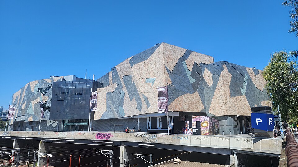 The angular patterned exterior of NGV Australia above the railway lines at Federation Square.