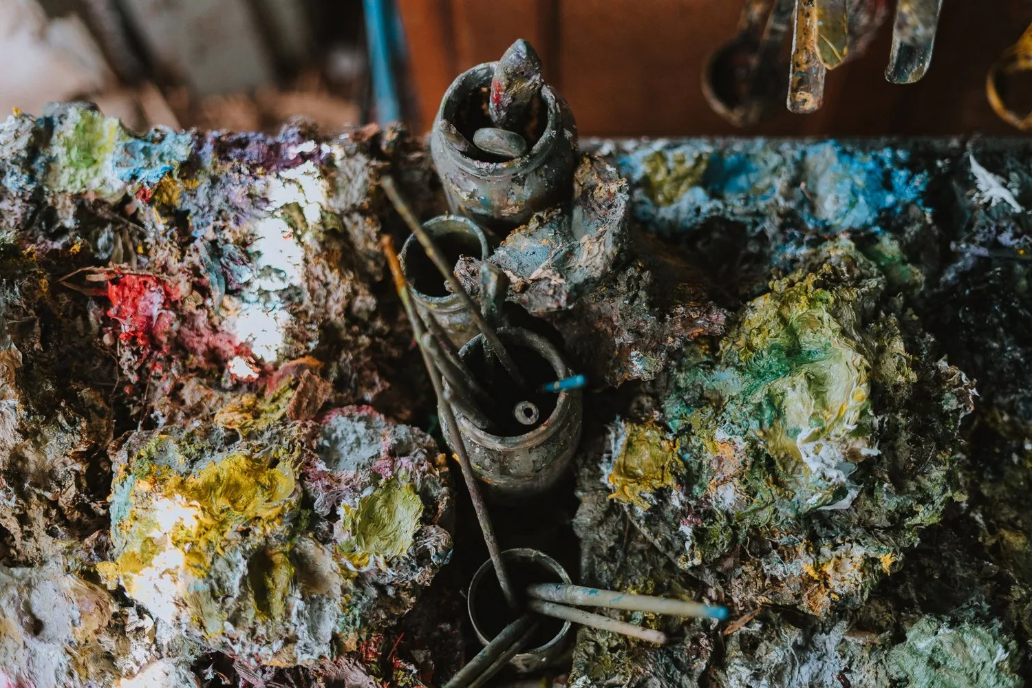 Paint and tools accumulated across a working palette.