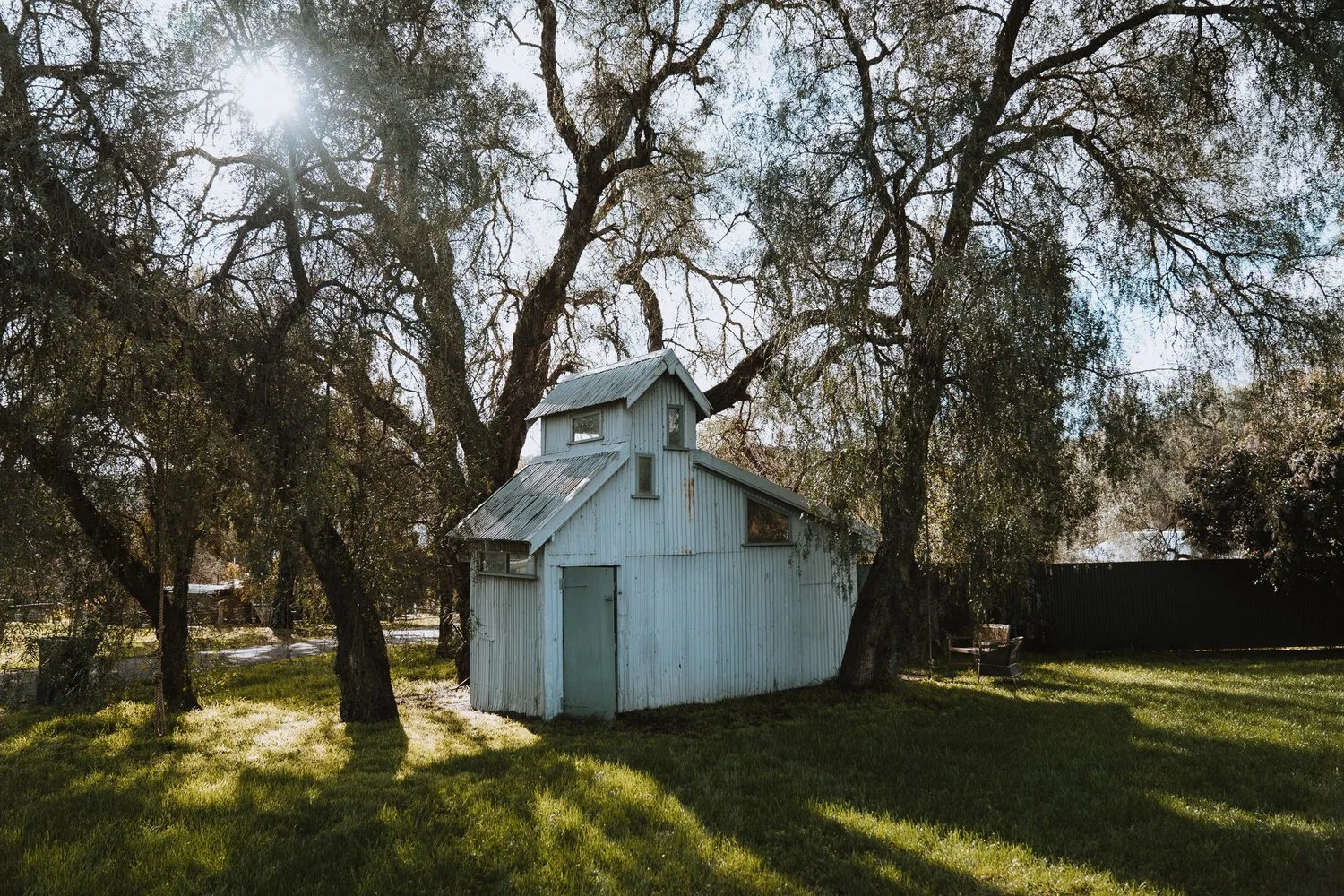 The studio building beneath trees.