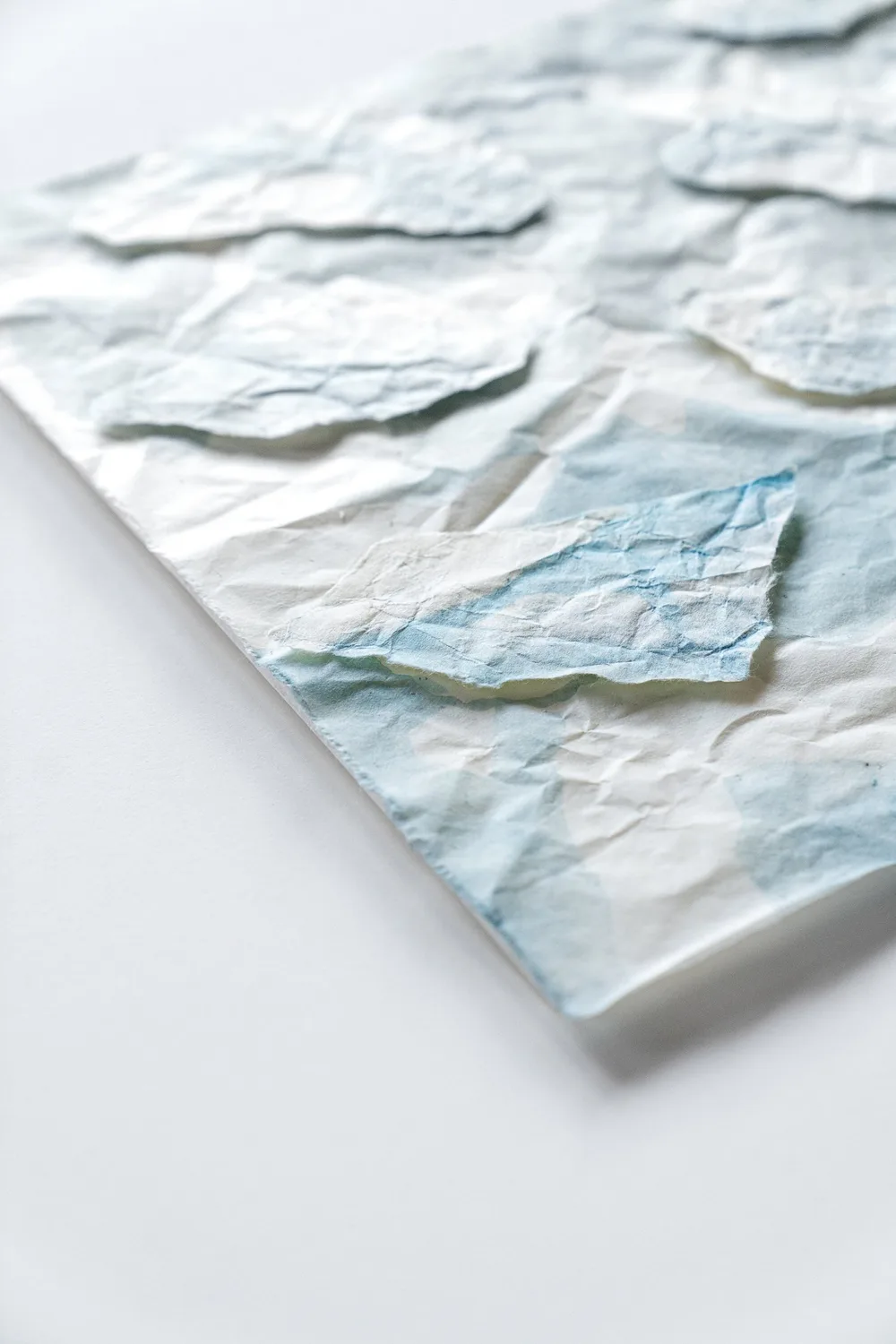 A folded corner reveals the work’s physical texture.