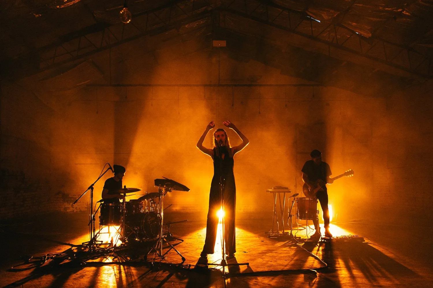 Musicians and equipment silhouetted in the performance space.