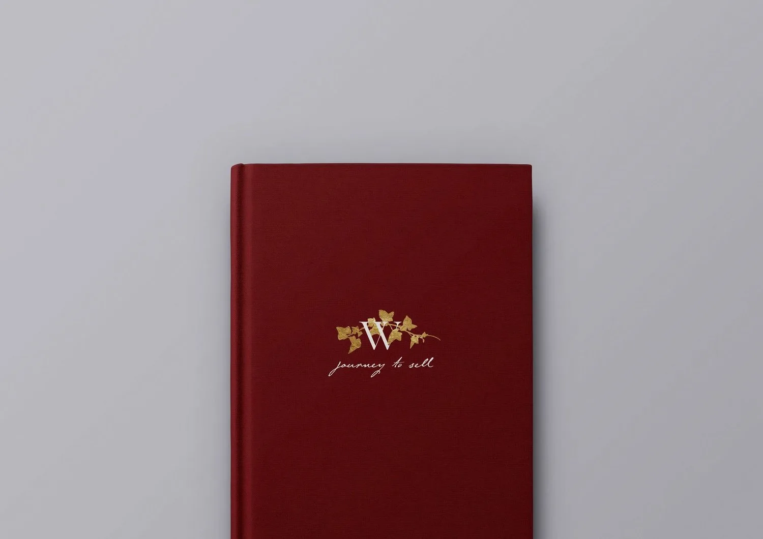 A deep red journal with gold-toned graphic details.