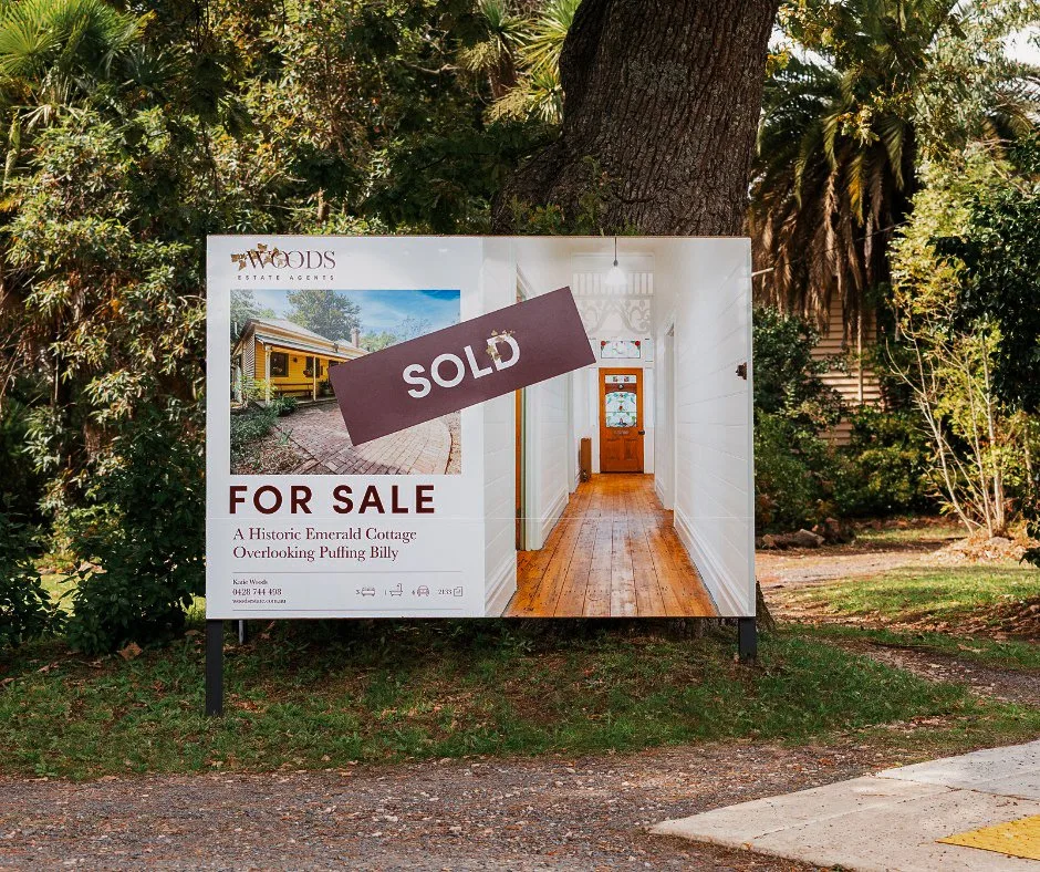 A Woods property sign displayed among trees.